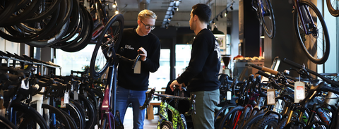 two men chatting in a bike shop